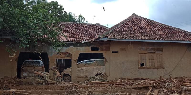 Dua unit mobil terseret banjir dan masuk kedalam rumah milik abah Jali, warga Kp. Somang, Kec. Sajira.(foto: Dimas)